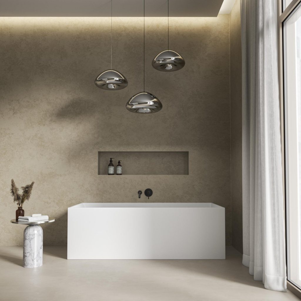 Modern stone bath with square angles and a triplet of hanging lights above in a contemporary styled space
